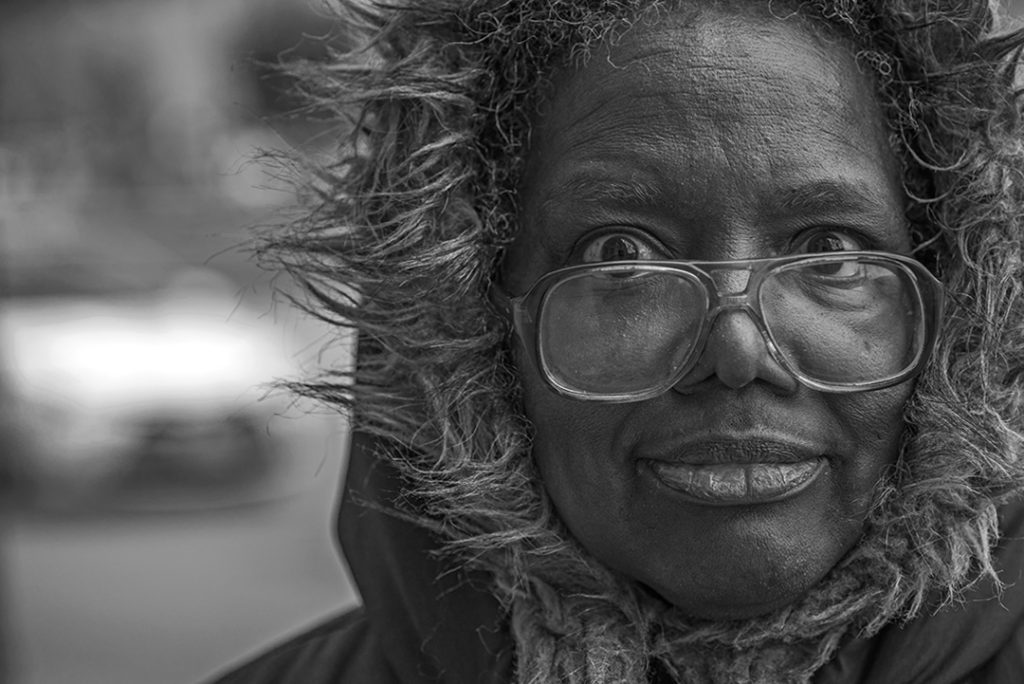 funny black and white street portrait of a woman wearing large glasses