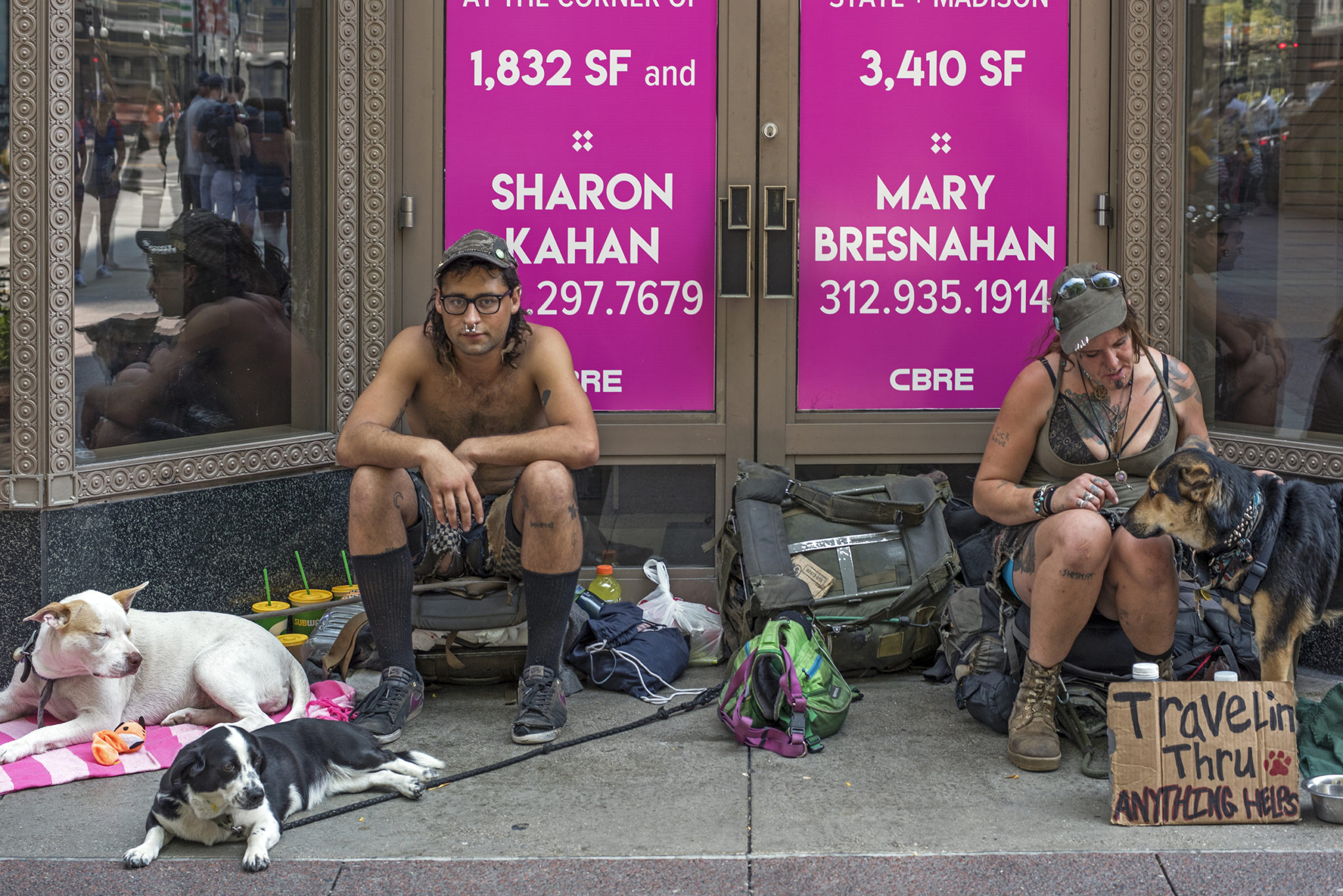 What is fine art street photography - A recluse couple sitting next to a building with their dogs and belongings.